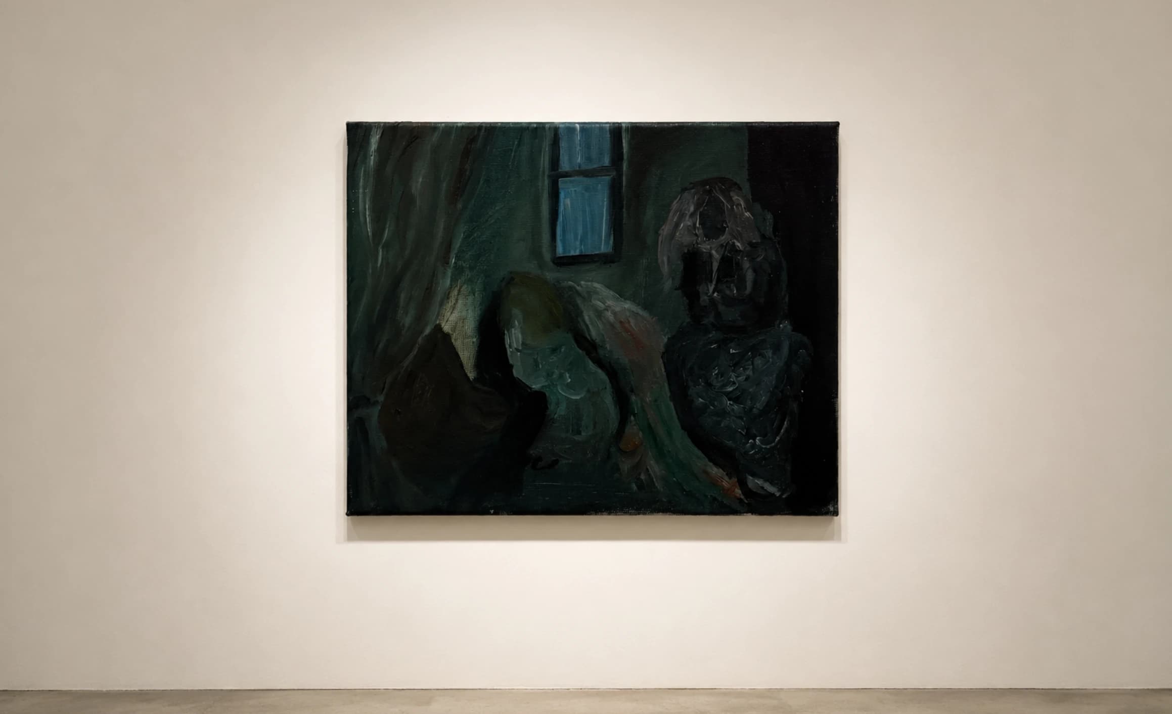 A horizontal painting of dark green and black forms, on a gallery wall.