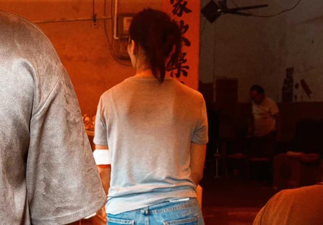 A person seen from behind in a warmly lit room.